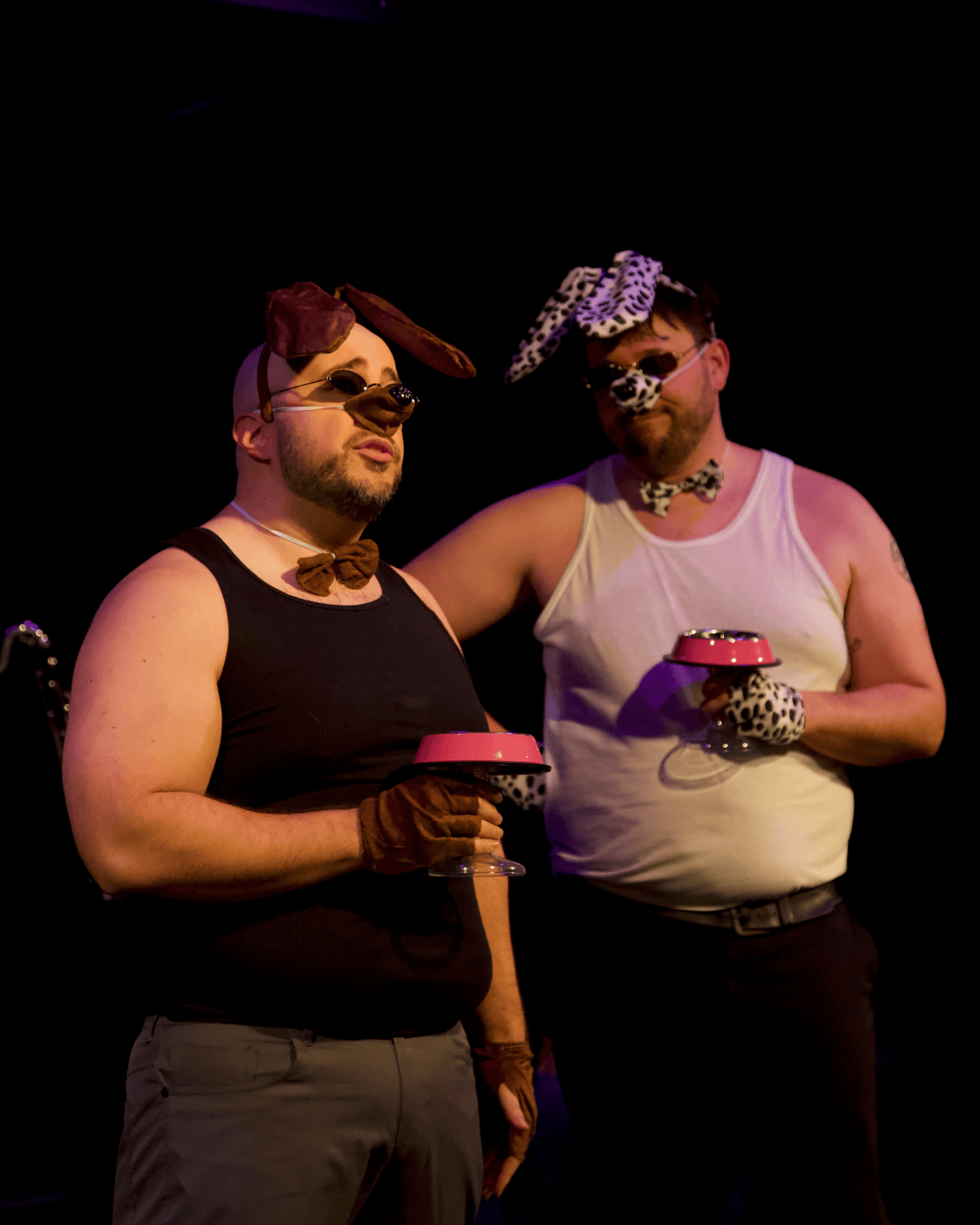 two people dressed as dogs sipping from dog bowls