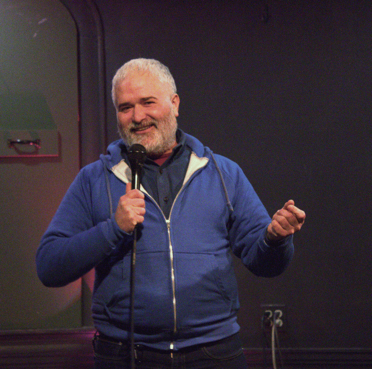 Rob Crean speaks into a microphone at Big Bang Stand-up