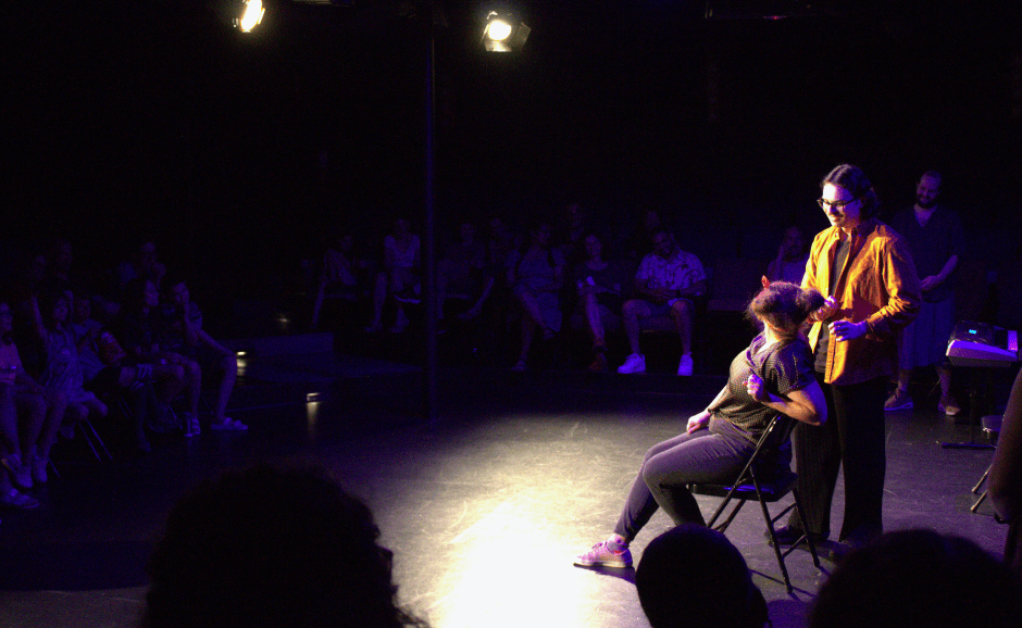 Two Adventure Improv cast members do a scene in front of a packed crowd